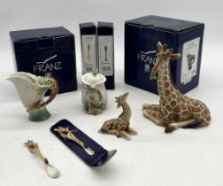 A collection of Franz giraffe porcelain including larger seated giraffe, baby giraffe (with box),