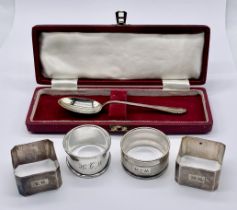 A cased silver spoon along with two pairs of silver serviette rings, total silver weight 93.3g