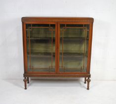 An antique oak display cabinet, with astragal glazing enclosing lined interior, with carved