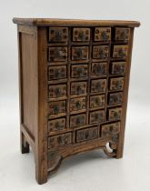 A small table top Chinese specimen/apothecary cabinet of 28 drawers, each drawer with character