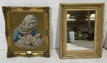 A gilt framed tapestry of the Virgin Mary and child along with a rustic pine mirror