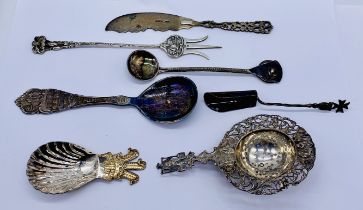 A small collection of continental and hallmarked silver including a tea strainer, caddy spoon etc.