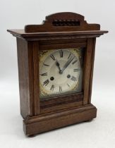 An oak cased clock with gilt detail to dial