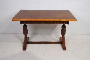 An oak draw-leaf refectory style table, with turned supports and carved decoration - length 122cm (