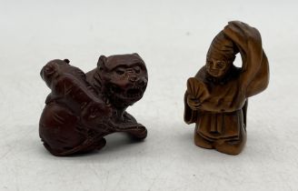 Two carved netsukes, one in the form of tiger and cub the other of monk, both signed