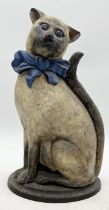 An early 20th century cast iron door stop modelled as a cat wearing a bow tie, stamped Nestor to