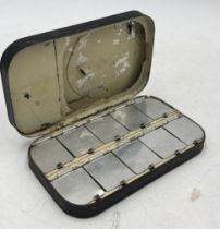 A vintage fly fishing tin box with numerous flies within