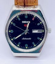 A vintage Seiko 5 automatic wristwatch with day and date aperture on leather strap