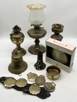 A collection of assorted items including brass bell, oil lamps, horse brasses etc