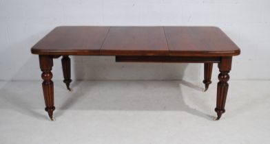 A Victorian mahogany rectangular extending dining table, with one extra leaf, raised on tapering