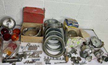 A large assortment of vintage car parts- lights and gauges including Triumph etc