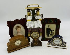 A two-bottle brass framed tantalus, along with two wooden photo frames, two inlaid mantle clocks and