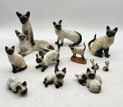 A collection of ceramic Siamese cats including Royal Doulton, Wade, Country Artists etc.