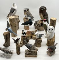 A collection of various carved and painted wooden birds including puffin, owl, woodpecker etc.