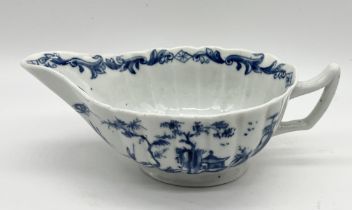 An 18th century blue and white sauce boat with oriental scenes to side