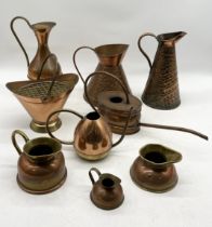 A collection of various copper jugs, watering cans etc.