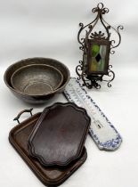 A collection of items including stained glass lantern, copper bowls, wooden trays, ceramic