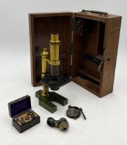 A turn of the century cased brass microscope with accessories including a small cased set of