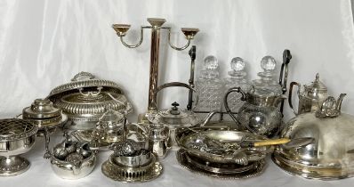 A large collection of silver plated items including cloches, Fink candlestick, decanter set,