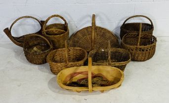 A collection of various wicker baskets, along with a wooden trug