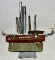 An assortment of vintage car chrome bumpers, a boot lid, overriders, chrome number plate holder,