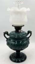A Victorian oil lamp on ceramic urn base with stylised dolphin handles and opaque shade - indistinct