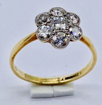 An 18ct gold daisy cluster ring set with 7 diamonds, size P