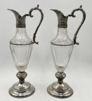 A pair of good quality cut glass carafes with silver plated base, collar and handle, single crown
