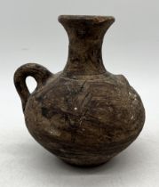 An early earthenware jug, possibly Roman, decorated with wheat sheaf motif with ribbed inner spout -