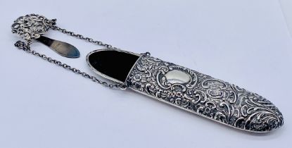 A Victorian hallmarked silver spectacle case with repousse decoration with chain leading to a