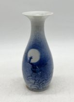 An Oriental porcelain vase with blue and white decoration showing flying birds across a night