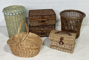 A collection of various wicker baskets including two picnic hampers, vintage waste paper basket