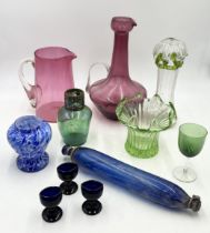 A collection of antique coloured glass including large cranberry jug, blue glass rolling pin etc.
