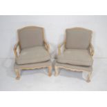 A pair of French style upholstered armchairs, with carved detailing