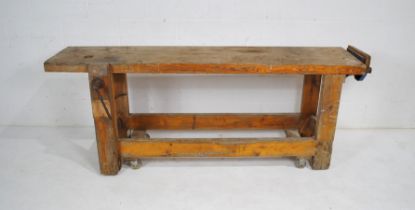 A rustic pine workbench on wheels, with a Record No 53 vice and a clamp - length (including vice &