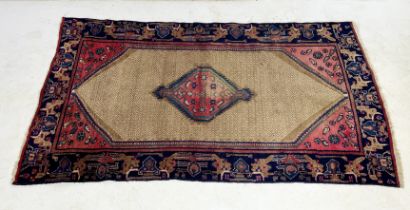 A Eastern red ground rug with central motif - 212cm x 122cm