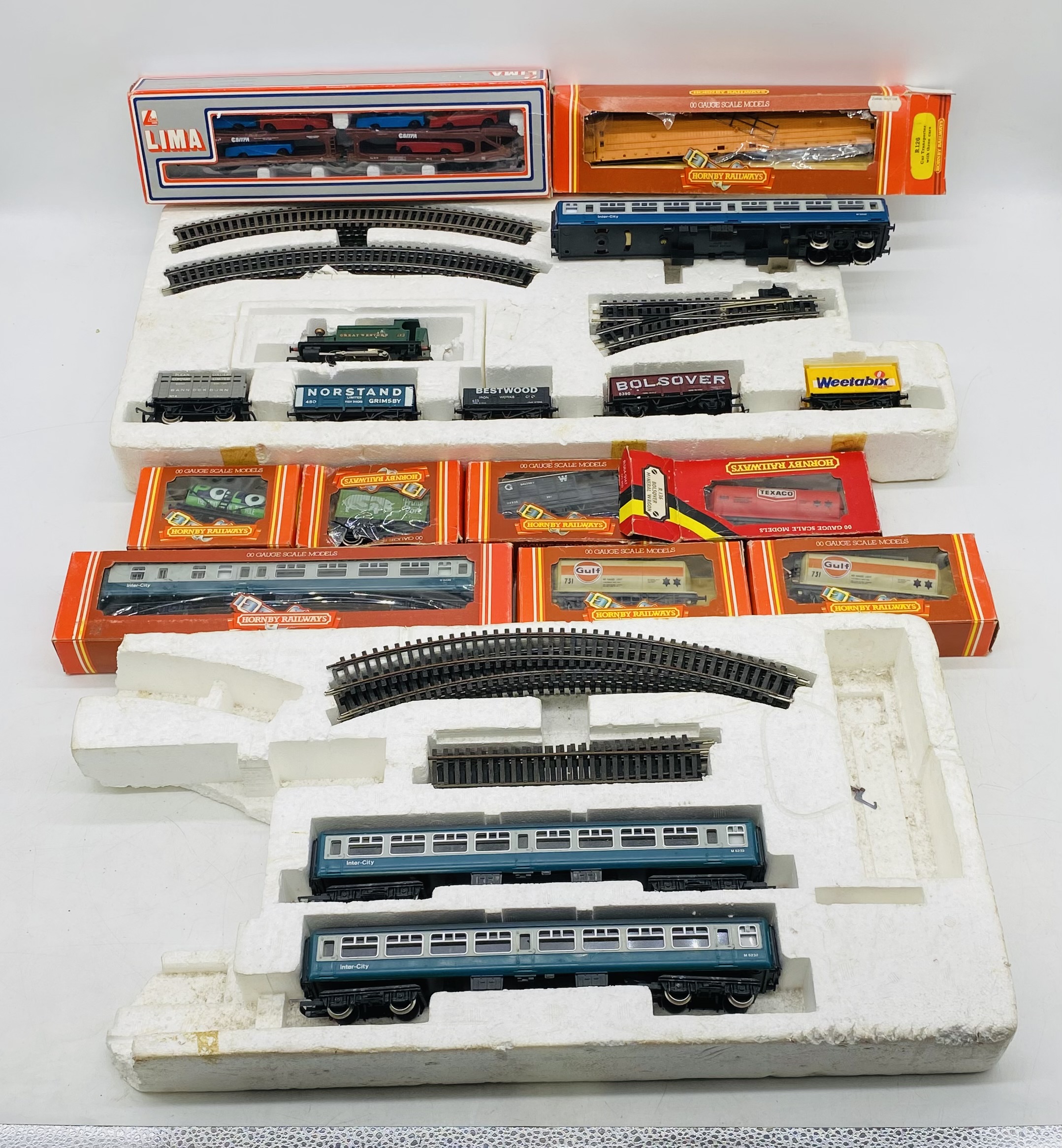 A collection of model railway OO gauge rolling stock, carriages, track and single locomotive.