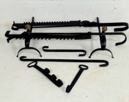 A collection of assorted cast iron fireplace accessories including a pair of fire dogs, hooks and