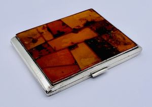 A continental silver cigarette case (835) the front set with a patchwork of amber, total weight