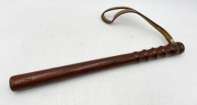 A vintage wooden truncheon with leather wrist strap