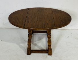 An oak drop leaf coffee table, width when extended 70cm, height 39cm.