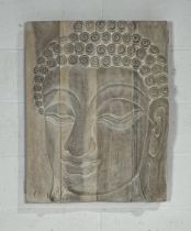 A large carved likeness of Buddha upon wooden panels. 60cm x 77cm