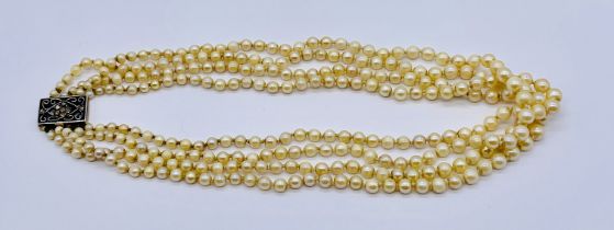 A four strand pearl necklace with unmarked gold clasp set with diamonds