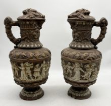 A pair of antique terracotta wine jugs with moulded relief of harvest scenes, Green Man motif to