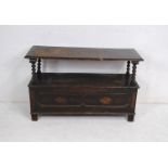A Jacobean style oak monks bench, with bobbin turned supports and lift up seat - in need of some