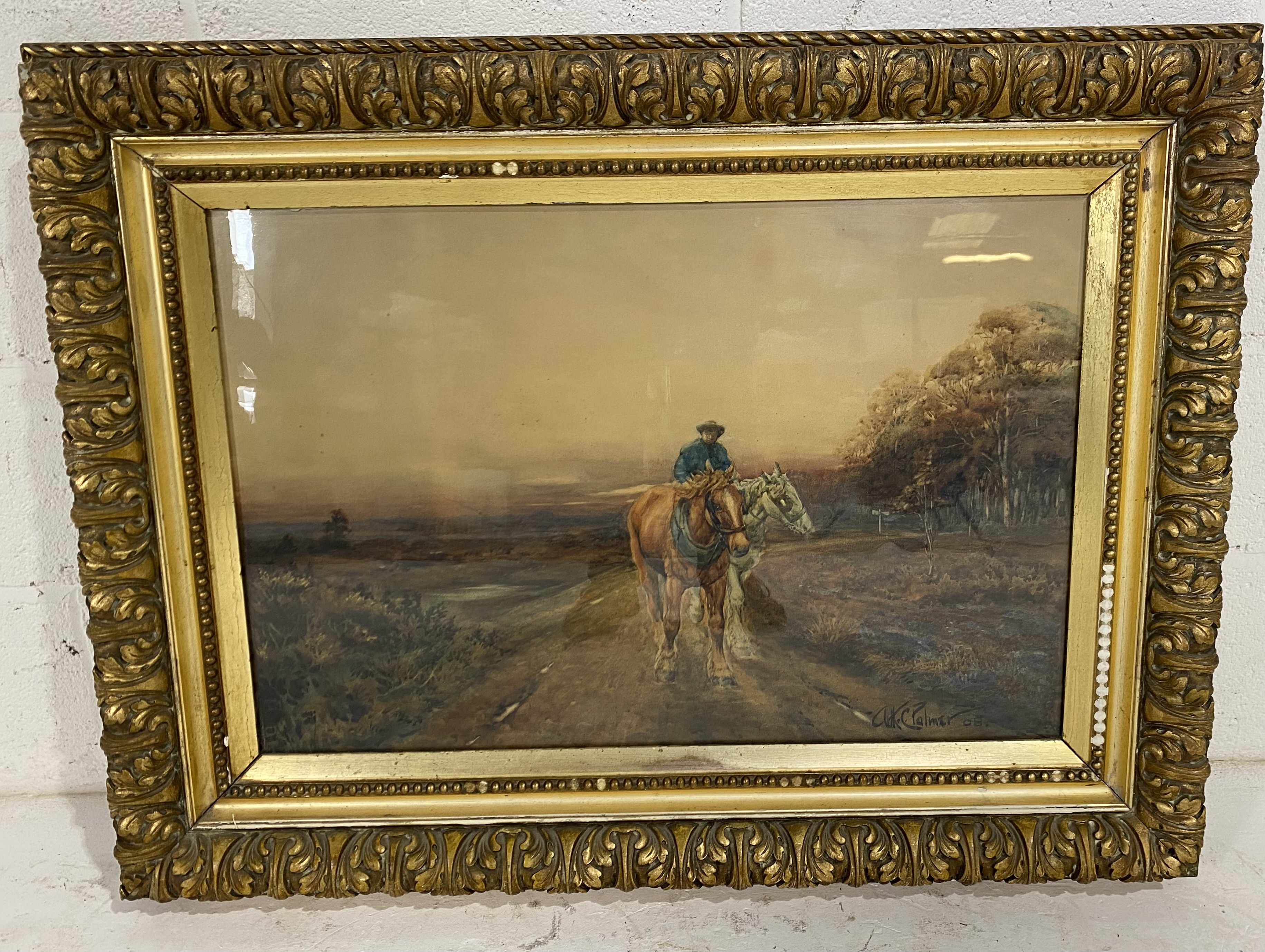 A large gilt framed watercolour of a man on horseback leading another horse signed Arthur C
