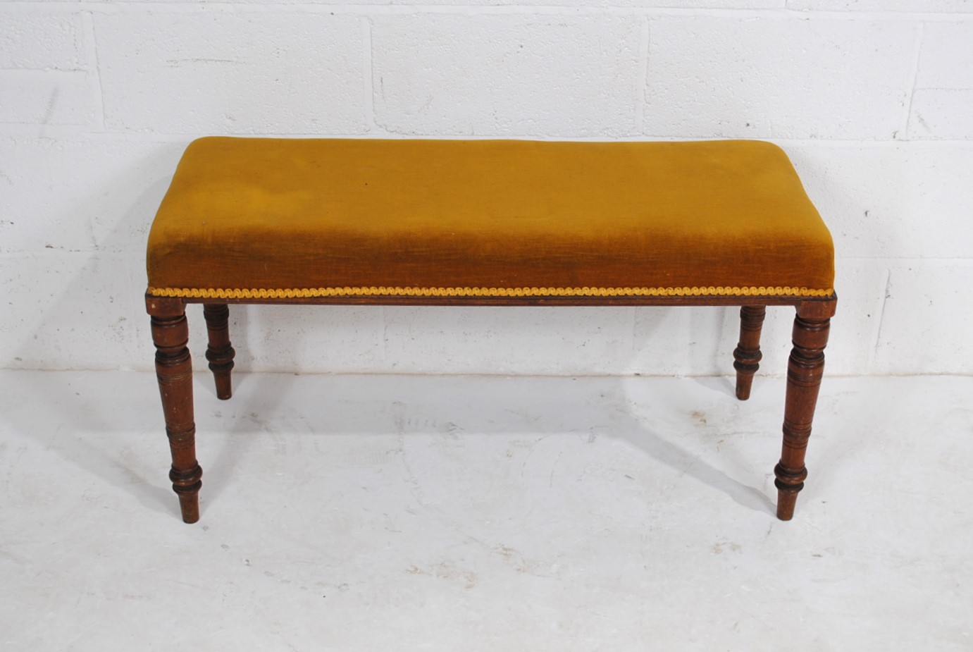A Victorian upholstered duet stool, raised on turned mahogany legs - length 99cm, height 51cm