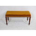 A Victorian upholstered duet stool, raised on turned mahogany legs - length 99cm, height 51cm