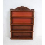 A Victorian mahogany waterfall bookcase, with leather covered ends in the form of books and carved