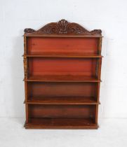 A Victorian mahogany waterfall bookcase, with leather covered ends in the form of books and carved